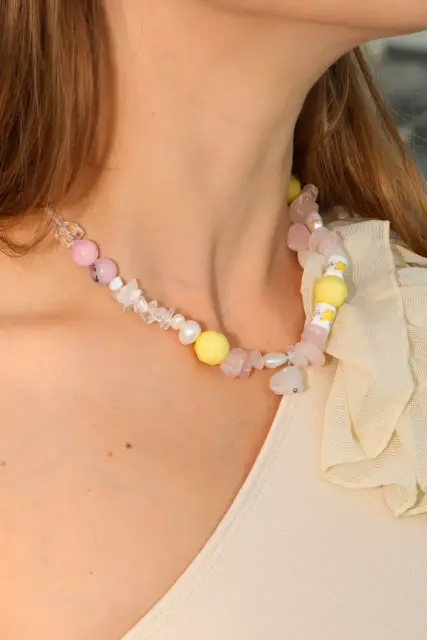 Soft pink meets bright lemon yellow, with floral details and a delicate pendant for a sunlit statement.