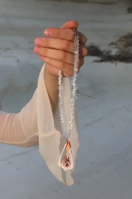 Clear and white details lead to a sculptural pink pendant: a striking necklace with a seaside mood.