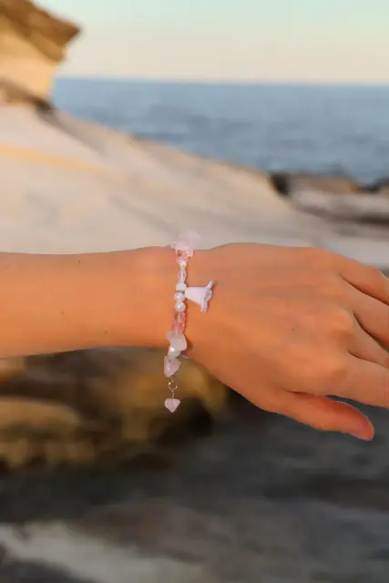 A delicate bracelet with blush-pink accents, clear details and a little flower pendant.