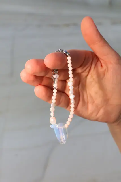 Soft peach tones and elongated iridescent accents give this delicate bracelet a dreamy glow.