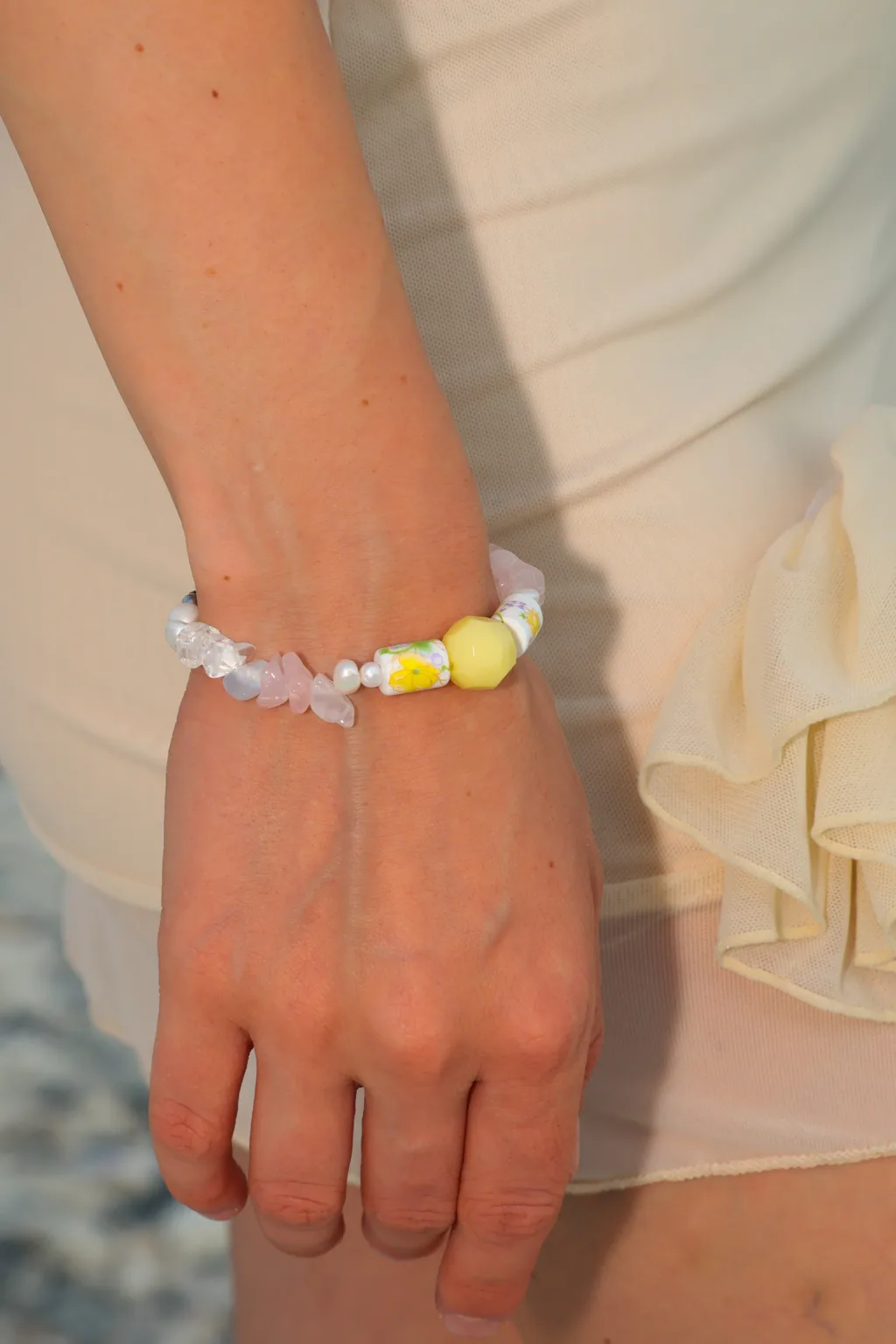 Sunny yellow accents, blush-pink details and floral beads bring a little summer garden to your wrist.